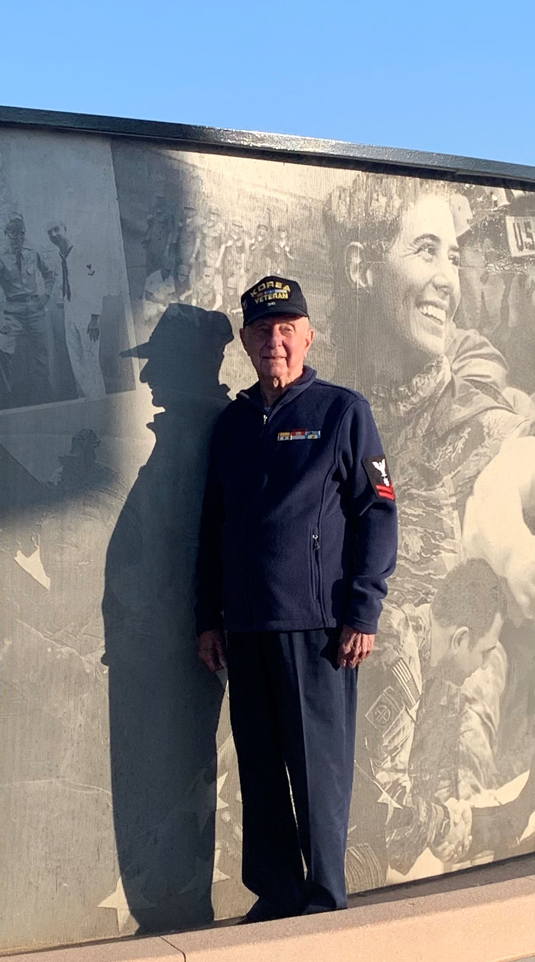 Floyd S. Dickson Jr. stands proudly next to the photo of him and his brother at the Adams County Veteran’s Memorial Story Wall. 