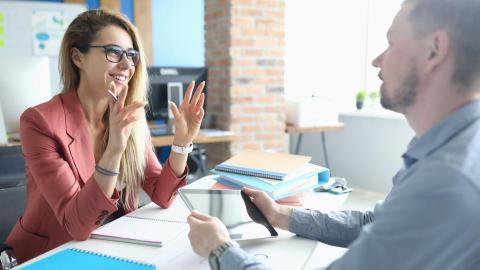 HR Generalist speaks with an employee at her desk